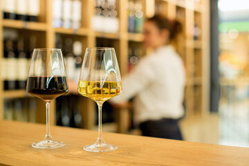 Young attractive woman, tasting wine in a wine store, enjoying glass of tasty wine