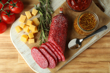 Сoncept of tasty food with salami sausage on wooden background