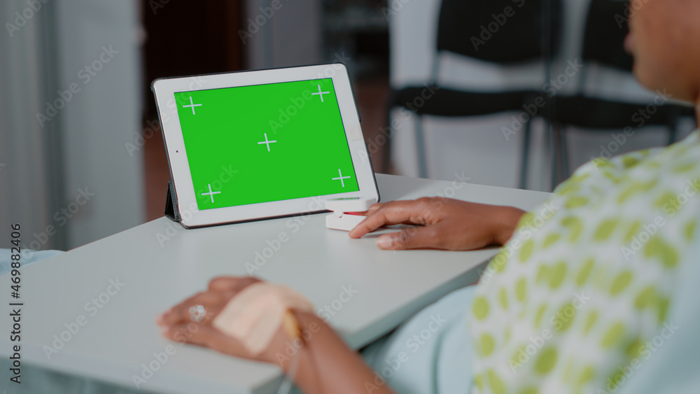 Poster close up of horizontal green screen on digital tablet in hospital ward. sick patient looking at isol