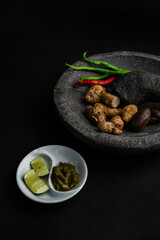 Asian spices at mortar or pestle kind of taste on black background 