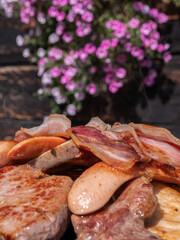 Variety of roasted bacon, sausages and meat with a traditional alpine rustic background in Livigno, Italy