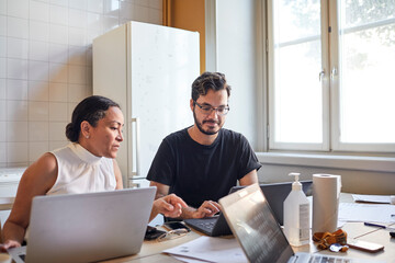 Woman and man using laptops