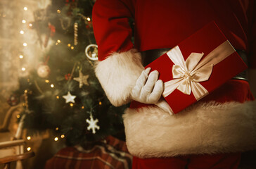 Santa Claus holding a present behind his back 