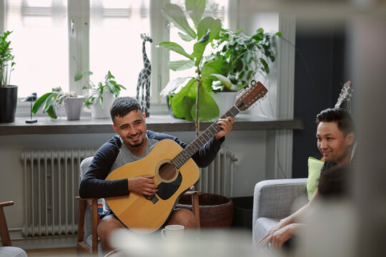 Smiling man playing guitar