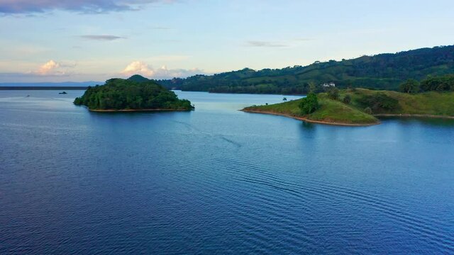 Drone flight over Hatillo dam showing lush surrounding landscape at sunset