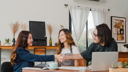 Cheerful Asian small business owners couple meeting with consultant talking about business plan and finance in cafe. Young Japanese agent consider signing contract insurance together at restaurant.