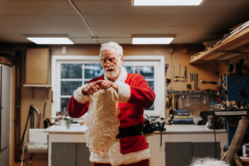 Senior man putting Santa costume on