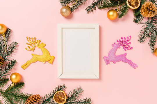 Minimal creative flat lay of winter christmas traditional composition and new year holiday season. Top view mockup black picture frames for text on pink background. Mock up and copy space photography.