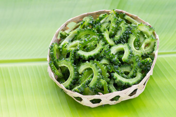 Sliced bitter gourd in bamboo basket on banana leaf