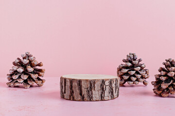 Podium or stage for product presentation on pink with pine cones