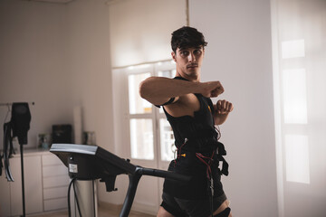 a young athlete hitting an elbow with an electrostimulation vest in a beauty clinic.