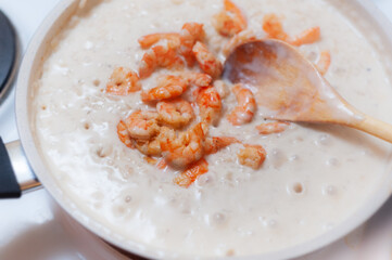 Cooking shrimp risotto in creamy sauce