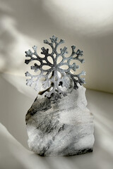 Minimal Christmas composition. Natural marble stand for presentation with  silver glitter snowflake.