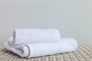 Fototapeta na wymiar Clean white towels folded on a brown wood table.