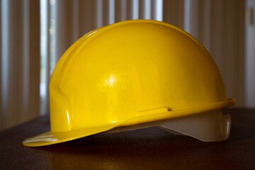 Yellow safety helmet on the table. Side view of yellow safety helmet.