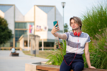 Young gay man taking selfie with mobile phone