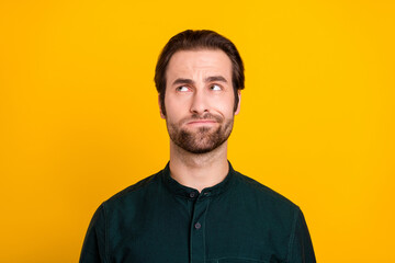 Photo of unsure millennial guy look promo wear green shirt isolated on yellow color background