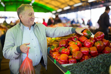 Middle aged man buying peppers