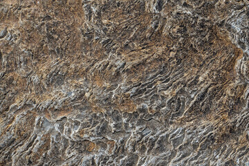 Rough stone surface with hint of warm yellow color. Abstract background for design.