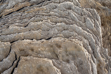 Rough stone surface with hint of warm yellow color. Abstract background for design.