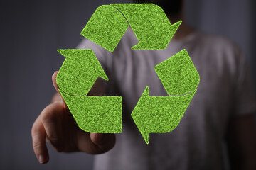 hand holding green recycle symbol