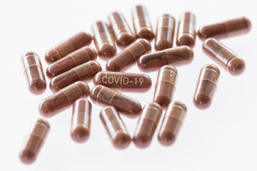 (Selective focus) Covid-19 pills on a white background. Concept of the new antiviral Covid-19 pill treatment which cuts the chance of ending up in hospital or dying..