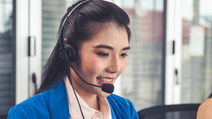Businesswoman wearing headset working actively in office . Call center, telemarketing, customer support agent provide service on telephone video conference call. - obrazy, fototapety, plakaty