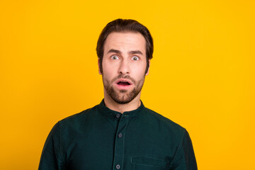 Photo of fear millennial guy open mouth wear green shirt isolated on yellow color background