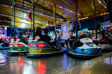 A small buy enjoys driving bumper car in an amusement park