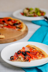 Vegetable salad with roasted meat and cheese and Sliced whole salami pepperoni pizza on a wooden table.