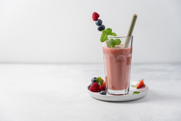 Glass of strawberry, blueberry and raspberry  smoothie on the table. Close-up and side view.