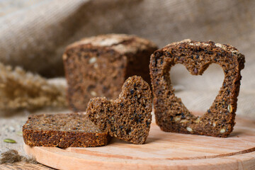 Healthy food concept. Carved heart from a piece of homemade bread. Selective focus on the heart.