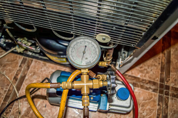 Vacuum pump of the refrigeration unit during repair. Refrigerator repair. Vacuum pump. Pressure...