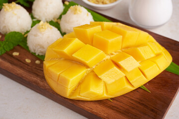 Ripe mango and sticky rice with coconut milk on wood plate on stone   background, Tropical fruit.  Dessert fruit. Thai sweet dessert on summer season.