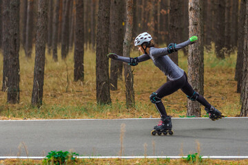 Roller skating sports girl in a helmet outdoors.
