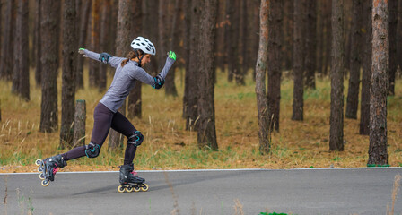 Roller skating sports girl in a helmet outdoors.