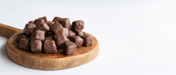 Chocolate covered Turkish delight on a white background. Traditional Turkish cuisine flavor. Empty space for text. Copy space