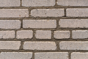 The weathered texture of old dirty white and gray brick wall background. Building