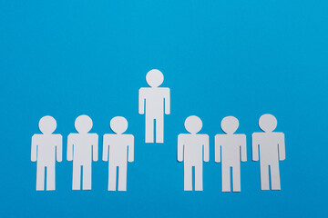 top view of white paper cut people in line near leader isolated on blue, team concept
