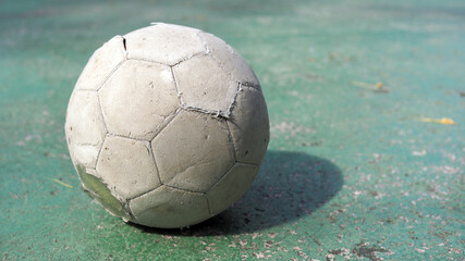 Old soccer ball. One abandoned soccer ball on cement floor.