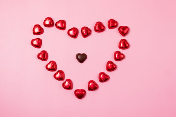Beautiful Red Chocolate Hearts Candies on Pink Background Valentine Day Holiday Background