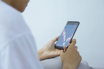 woman pointing, look directions change Average line Share price movement Stock trade up and down economy on smartphone work in the bedroom