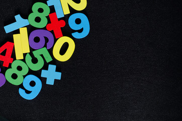Top view of colorful wooden numbers on black background	