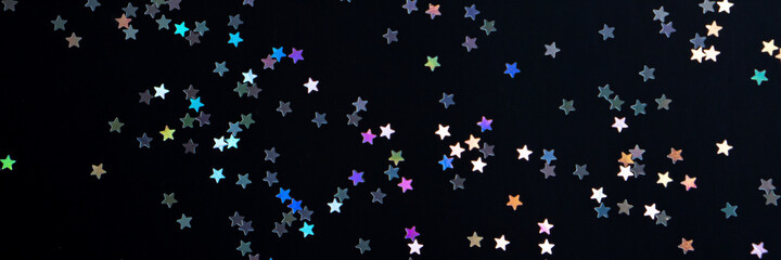 Festive black paper background with many many silver stars. Christmas, New Year or Birthday theme concept. An ideal backdrop for your banner or web design. Banner for happy holidays presentation