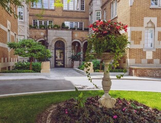 Fototapeta premium View on a facade of an old building from behind the stone flower vase