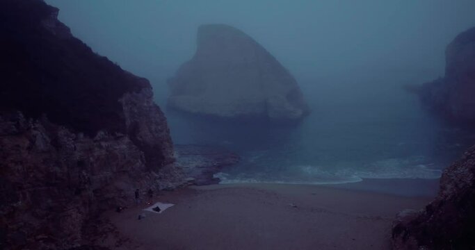 Aerial over foggy beach at sunset, Santa Cruz, Davenport beach, shark fin cove, California