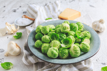 Raw Brussel sprouts with salt and Parmesan cheese in bowl