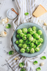 Raw Brussel sprouts with salt and Parmesan cheese in bowl
