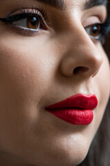 Fototapeta premium Beautiful young woman with make up and red lips