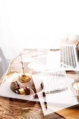 Justice and law concept.Male judge in a courtroom with the gavel, working with, computer and docking keyboard, eyeglasses, on table in morning light